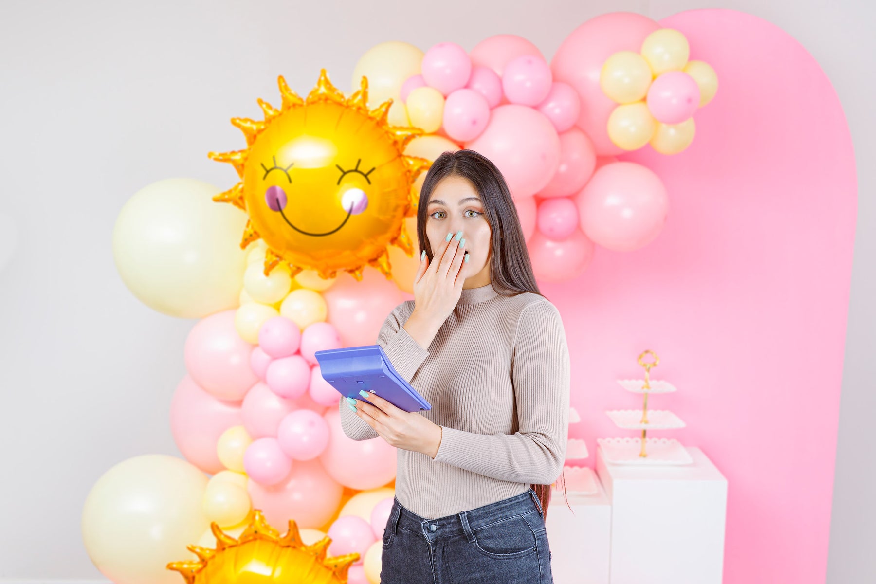 lady with calculator in front of balloon garland